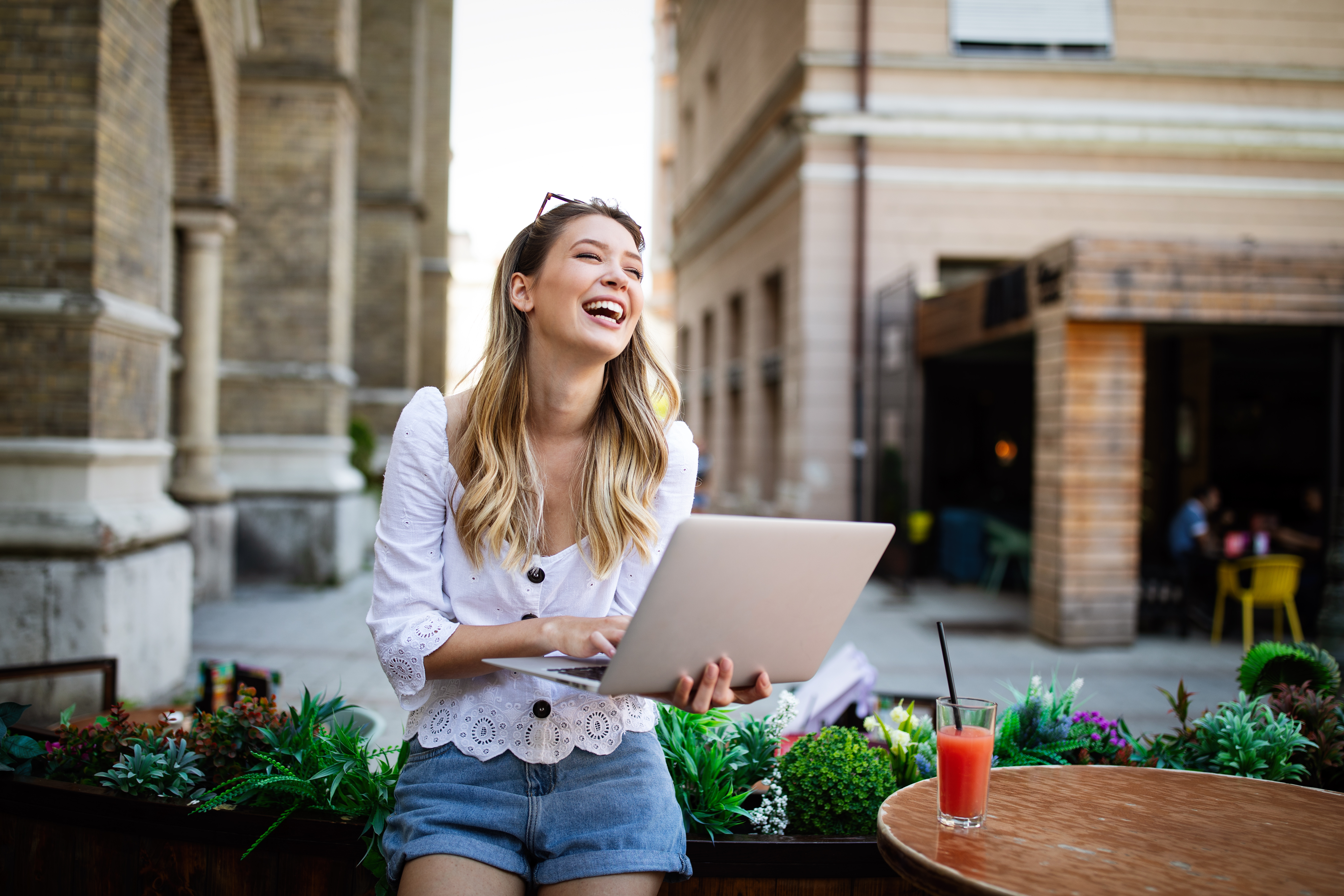 Excited woman reading good news on line in a laptop outdoor